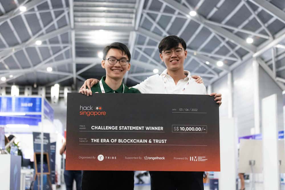 two guys holding a big hack Singapore check