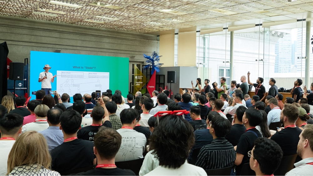 A person speaking onstage addressing a crowd at the Ethereum Singapore event